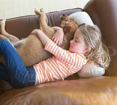 Une jeune fille dort sur un canapé en cuir avec son chien